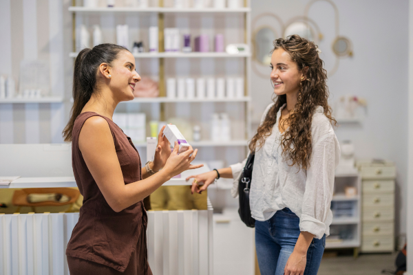 Retail shop owner serving a customer at the counter Retail shop owner serving a customer at the counter