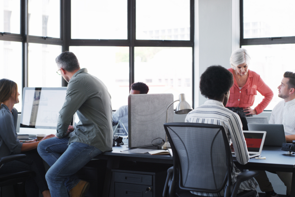 A growing team in a busy office setting with individuals working independently, symbolising misalignment.