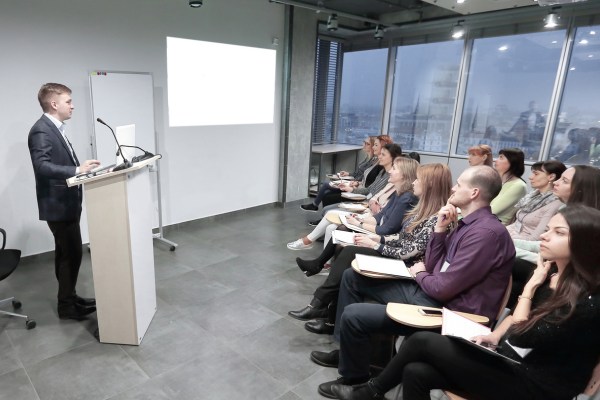 A confident business owner presenting at a workshop or speaking to clients, symbolising authority and trust.