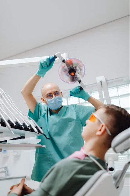 Dentist adjusting the overhead light before treatment