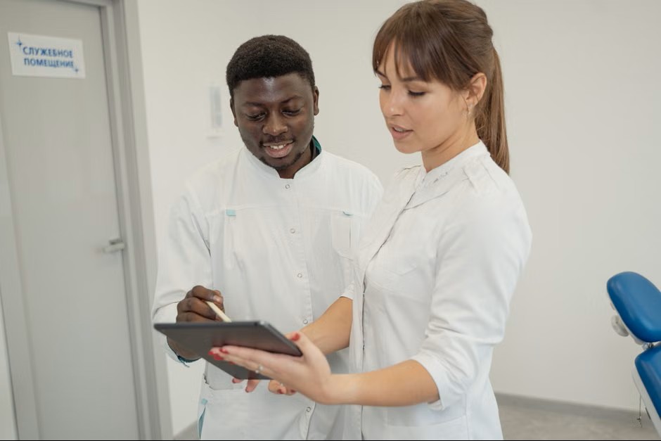 Two dental professionals discussing data on a tablet