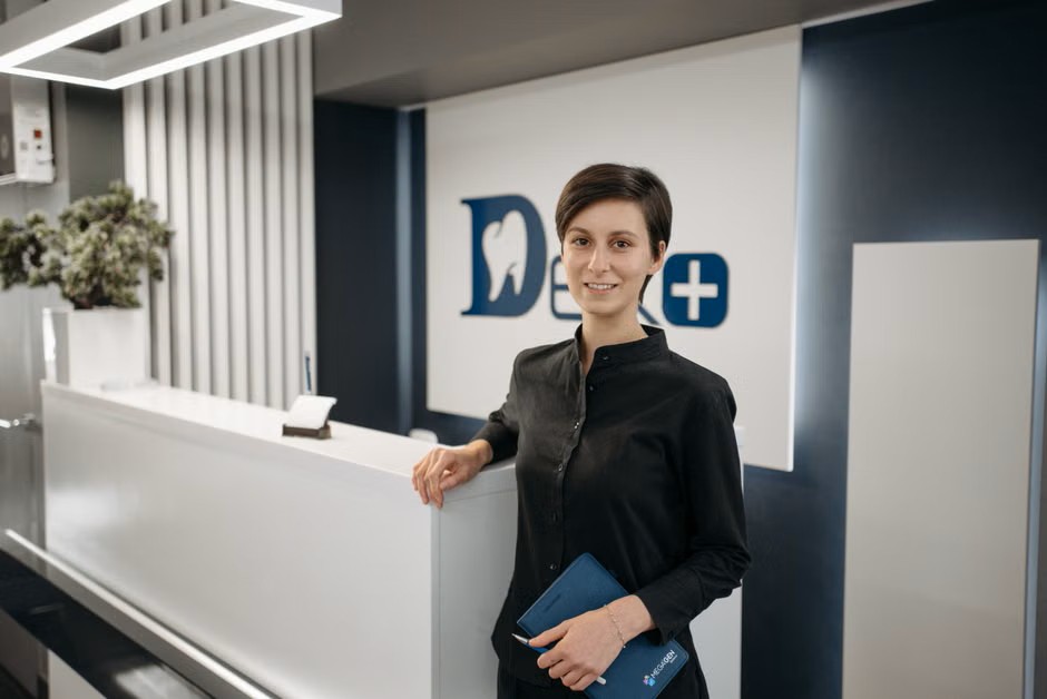 Front-desk team member in a dental office lobby