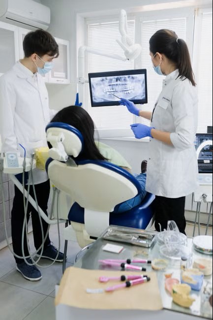 Two dentists reviewing an X-ray on a monitor