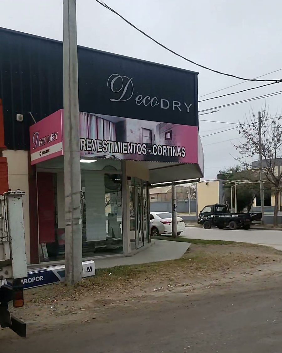 Fachada del local DecoDry en Almafuerte con cartel de revestimientos y cortinas