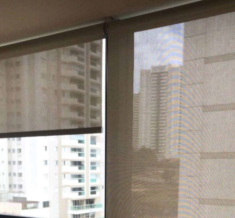 Cortina roller sunscreen 5 % frente a un ventanal con vista a la ciudad