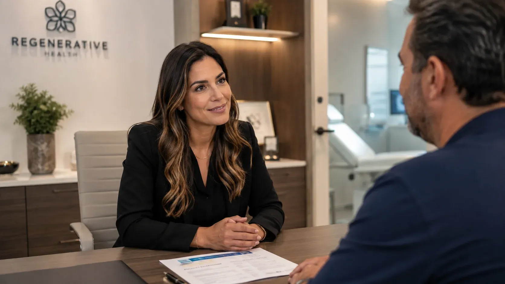 Regenerative health clinic consultation coordinator in engaged patient conversation showing trust-based enrollment discussion not a sales pitch
