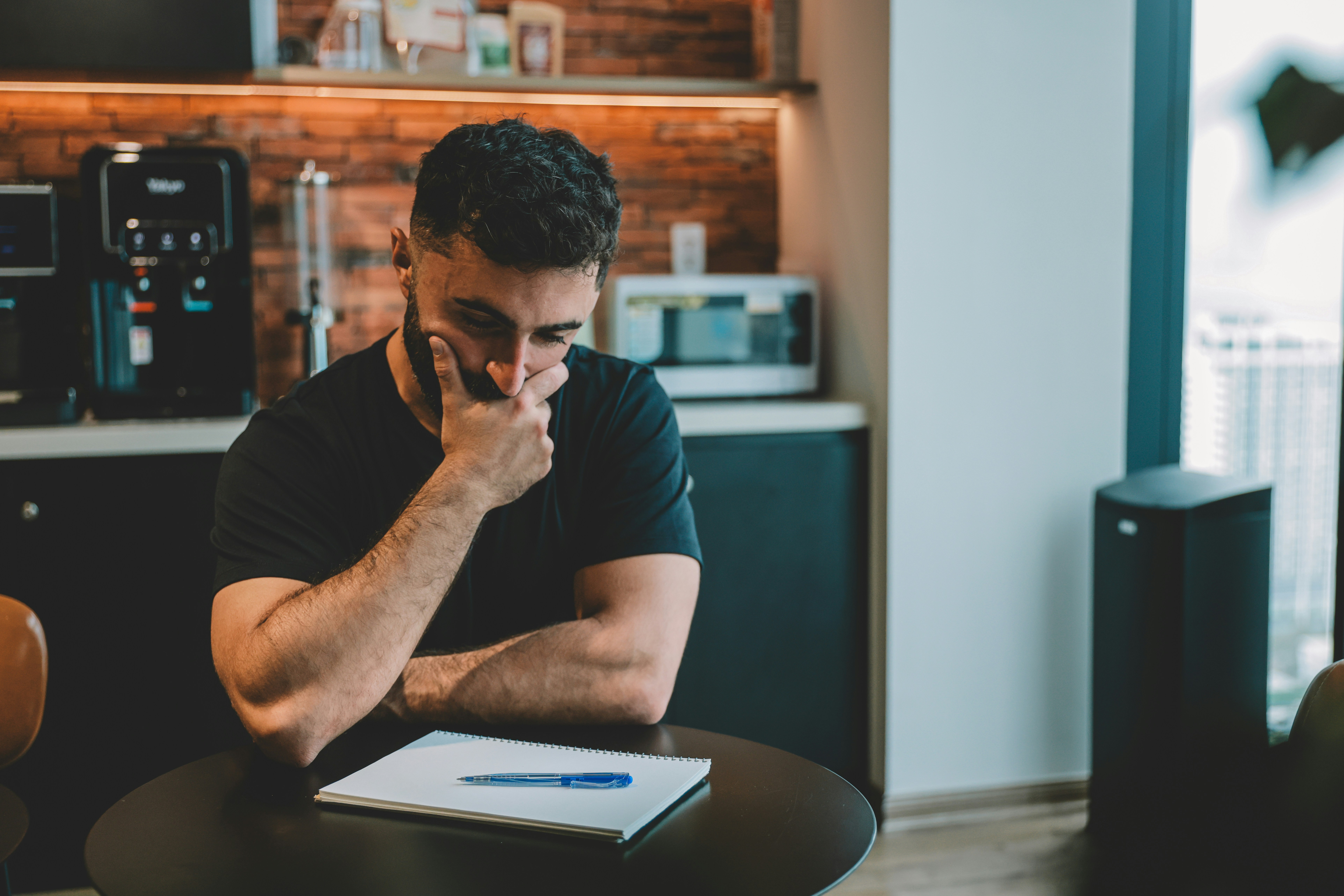 Tired professional reflecting after a workday, suggesting the cost of invisible labour Tired professional reflecting after a workday, suggesting the cost of invisible labour