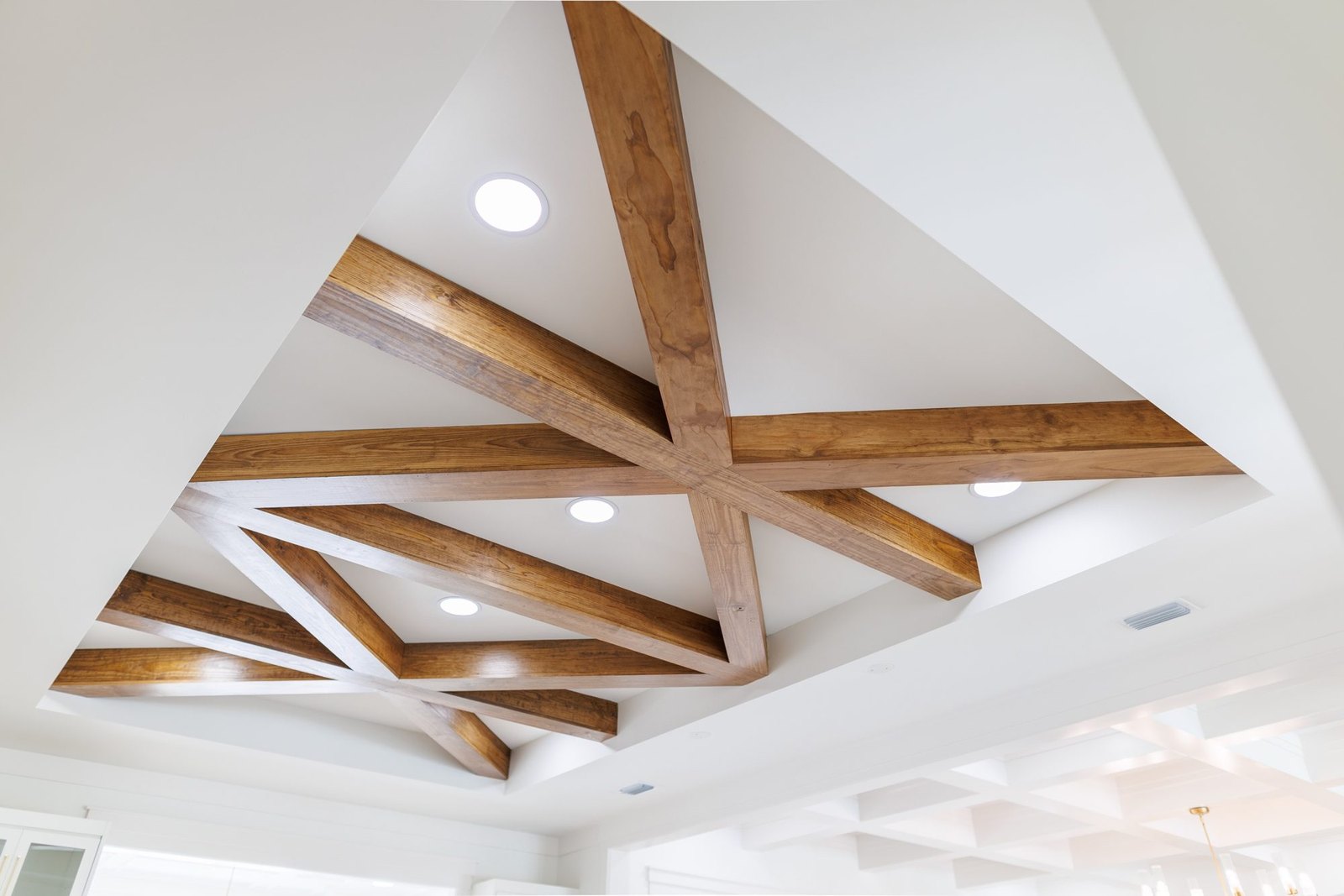 Stained wood beams in a starburst pattern on a white ceiling