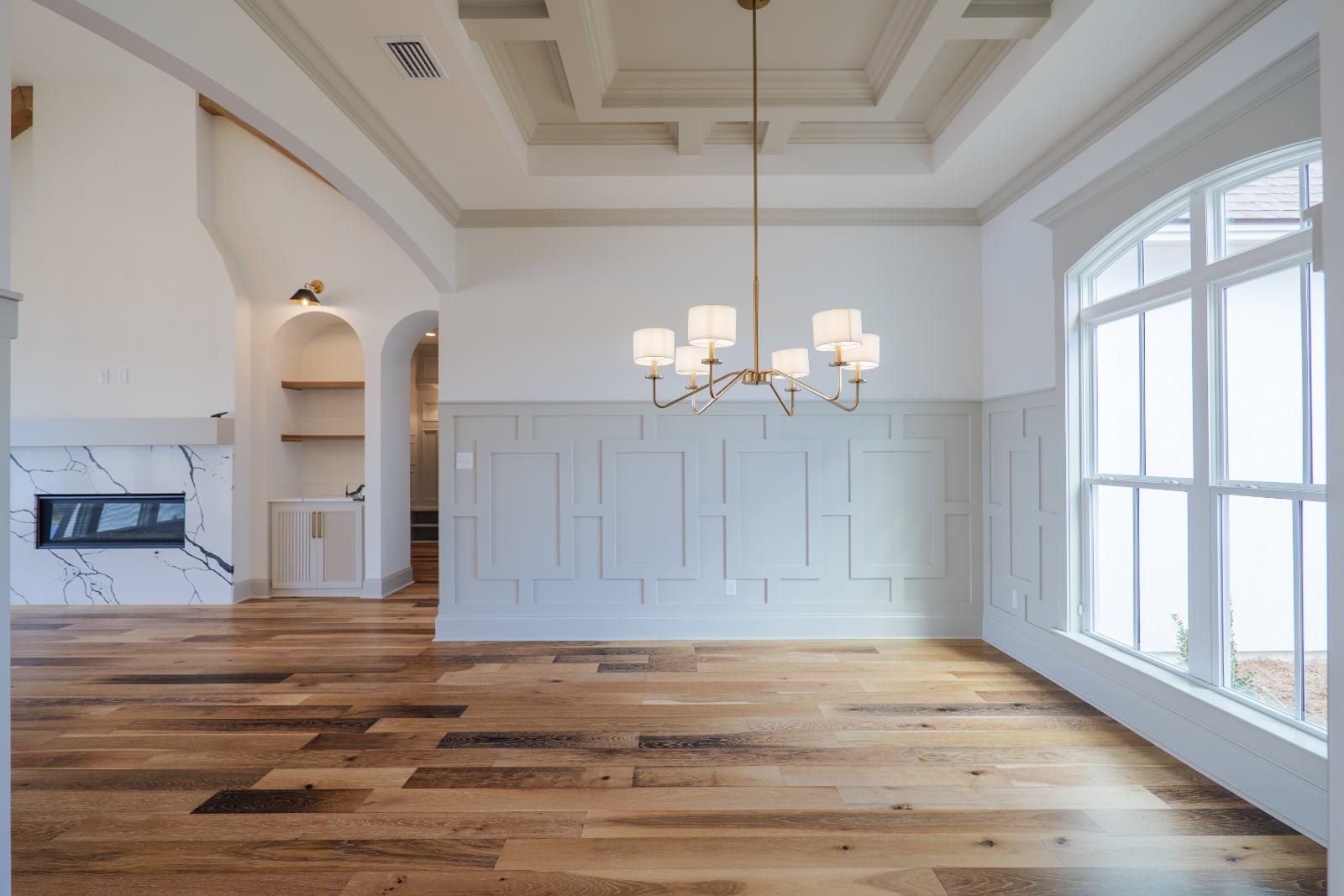 Dining room with picture-frame wainscoting and a coffered ceiling