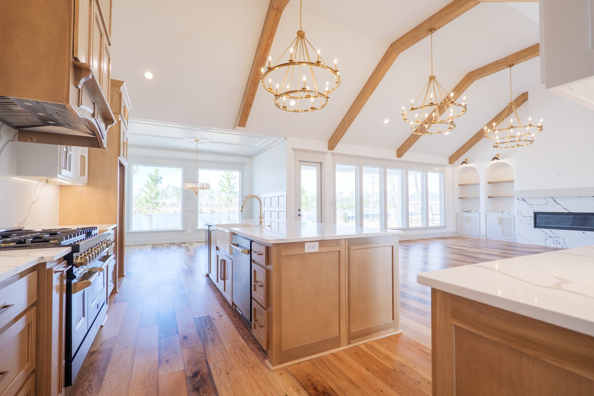 Kitchen island looking out to the lake under three chandeliers