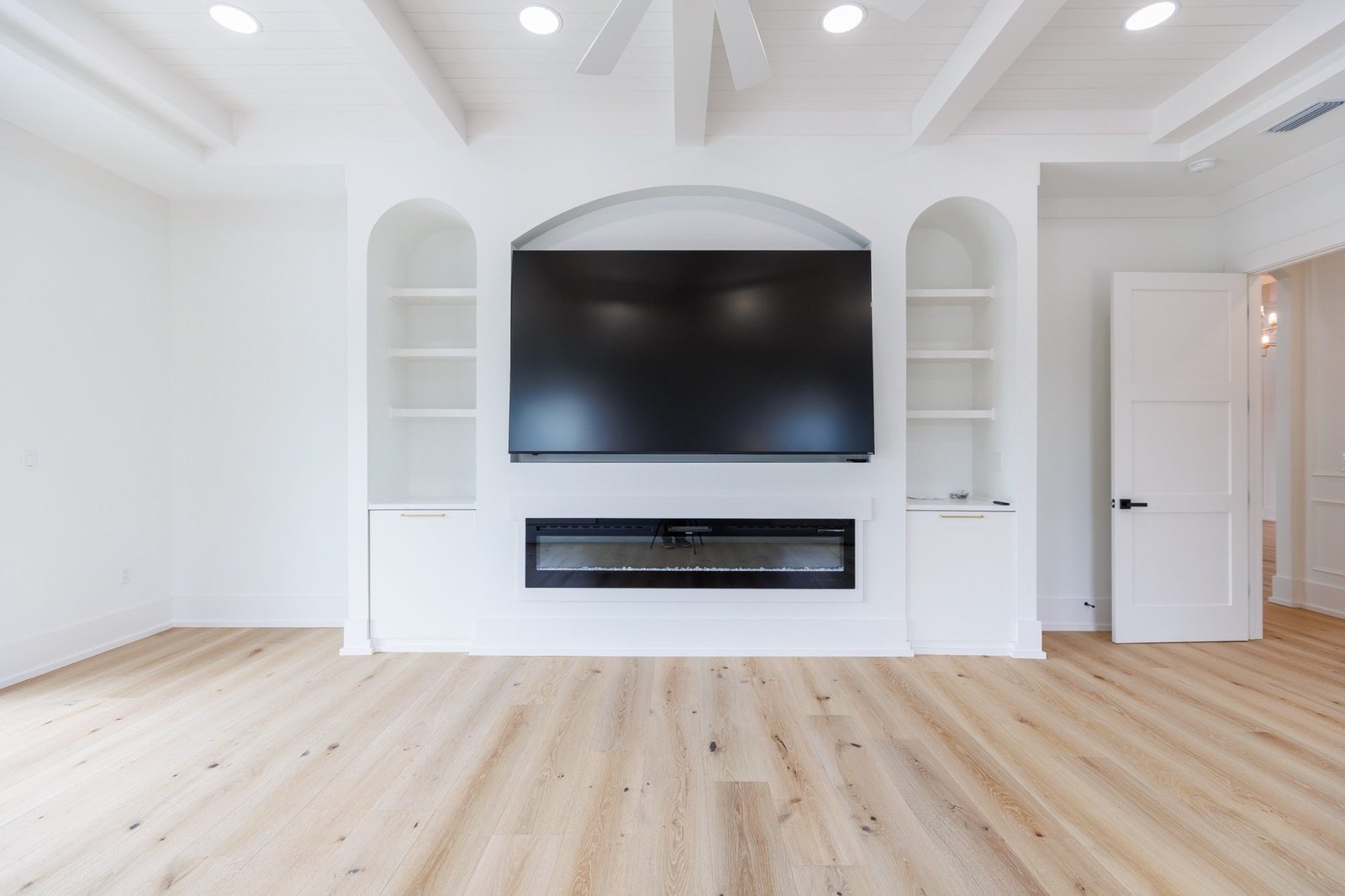 Primary bedroom with built-in shelving, a fireplace wall and a coffered ceiling