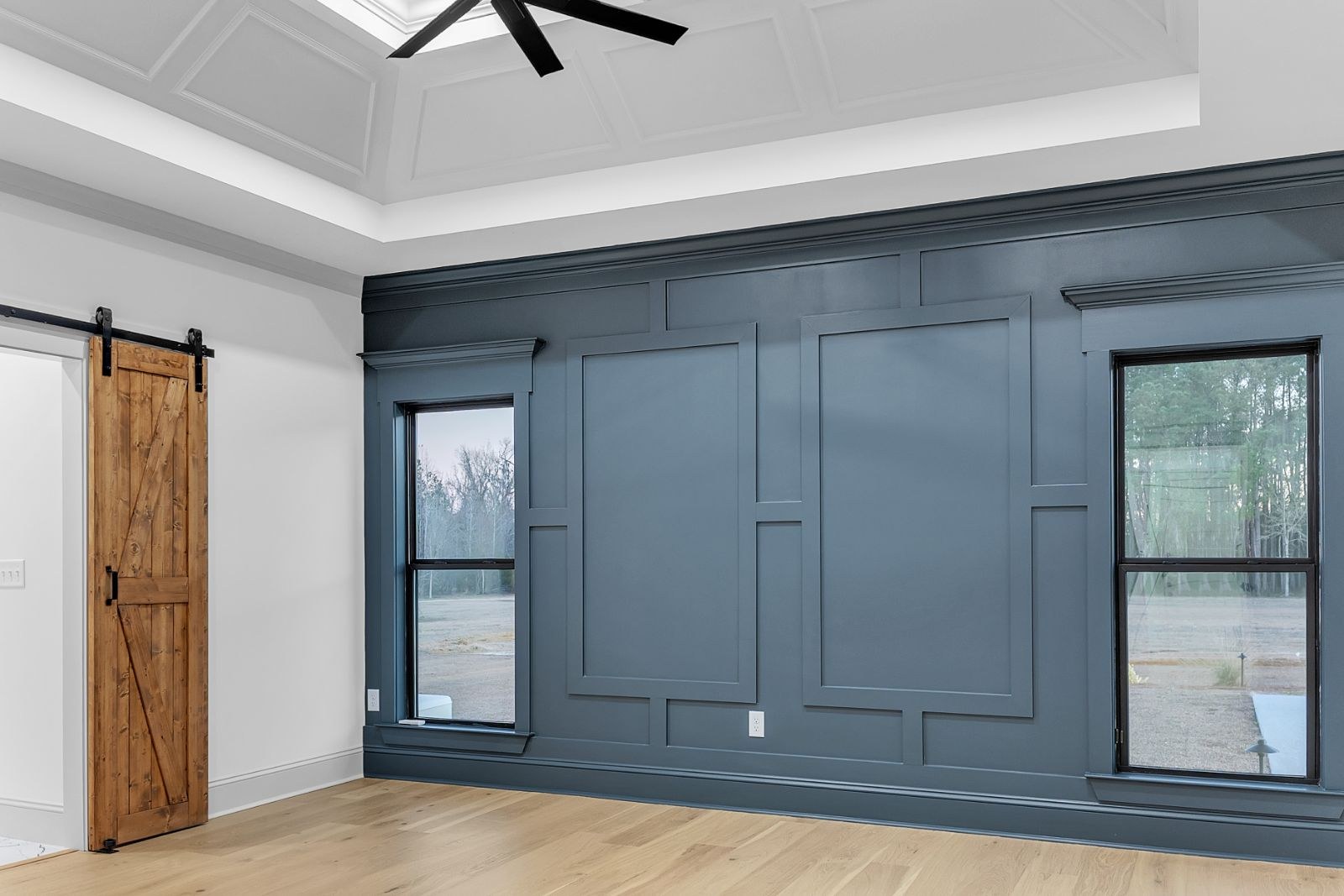 Room with a navy board-and-batten wall and a sliding barn door