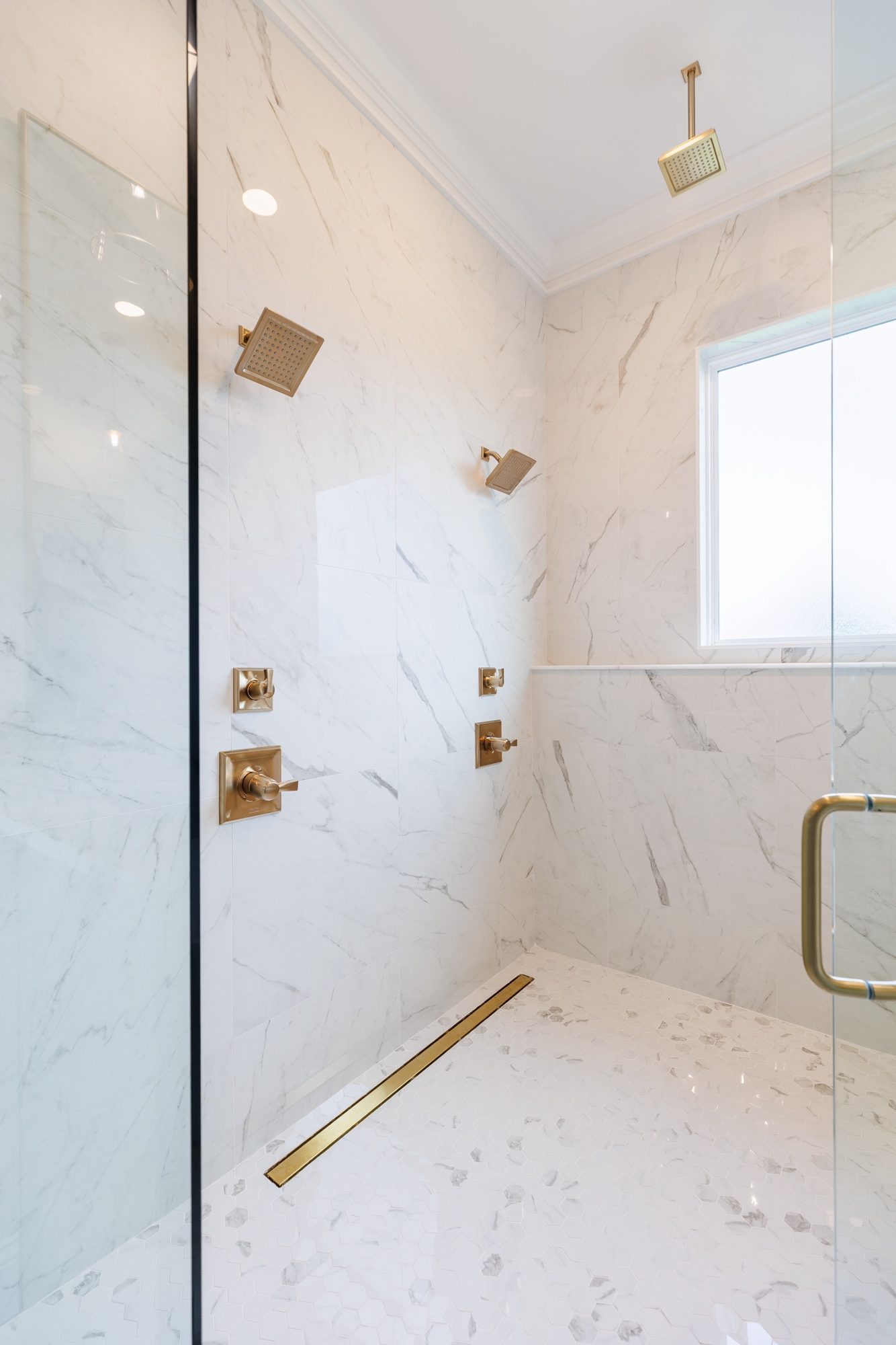 Curbless walk-in shower with a brass linear drain