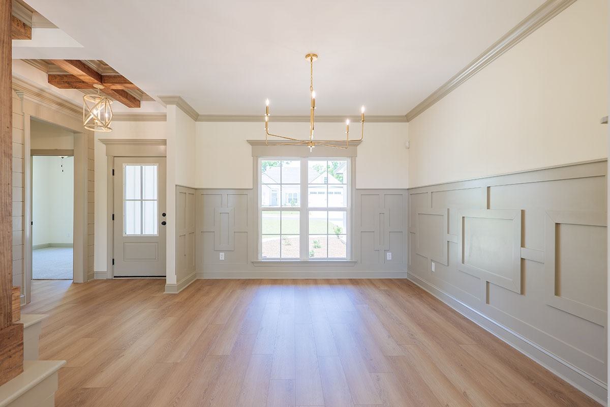Dining room with picture-frame wainscoting and wood beams
