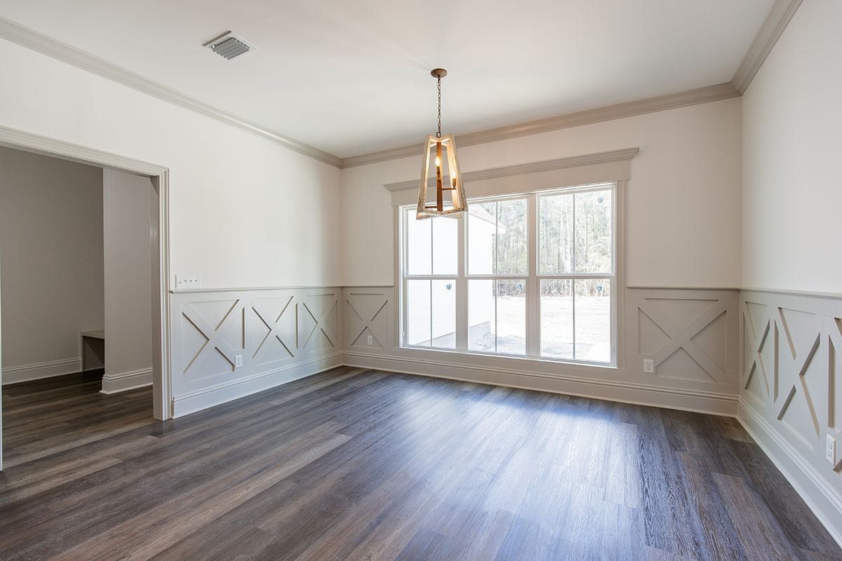 Dining room with X-panel wainscoting and a brass chandelier