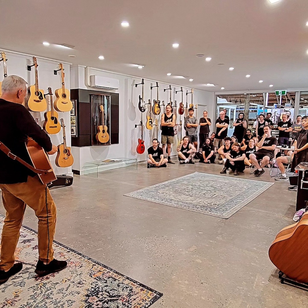 Tommy Emmanuel demonstrating acoustic guitar techniques for a live audience