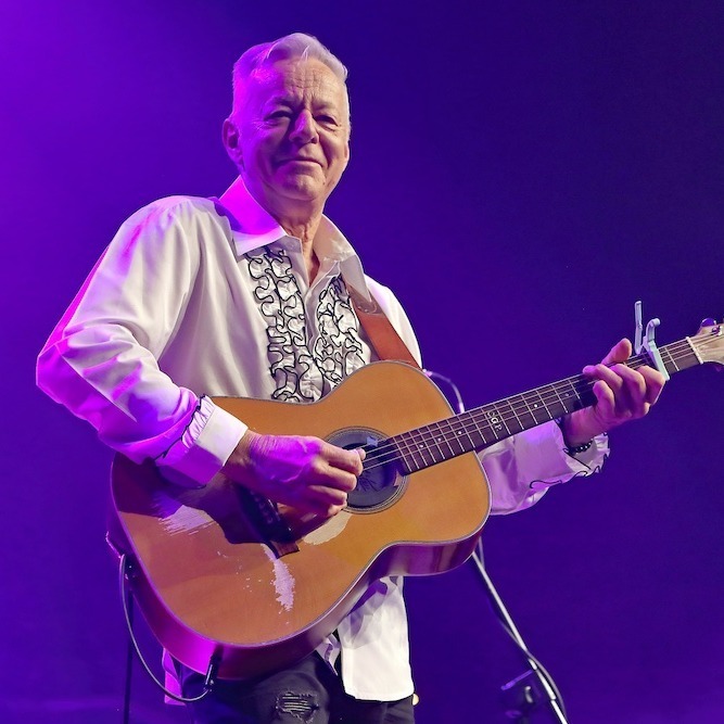 Tommy Emmanuel performing onstage with an acoustic guitar