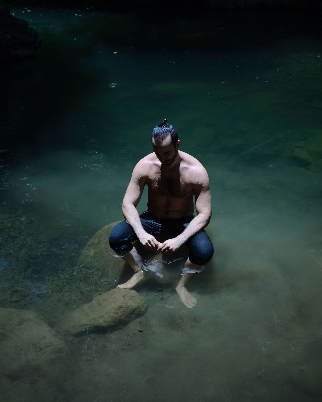 Luke seated in shadowed water, symbolizing the protector and the wound