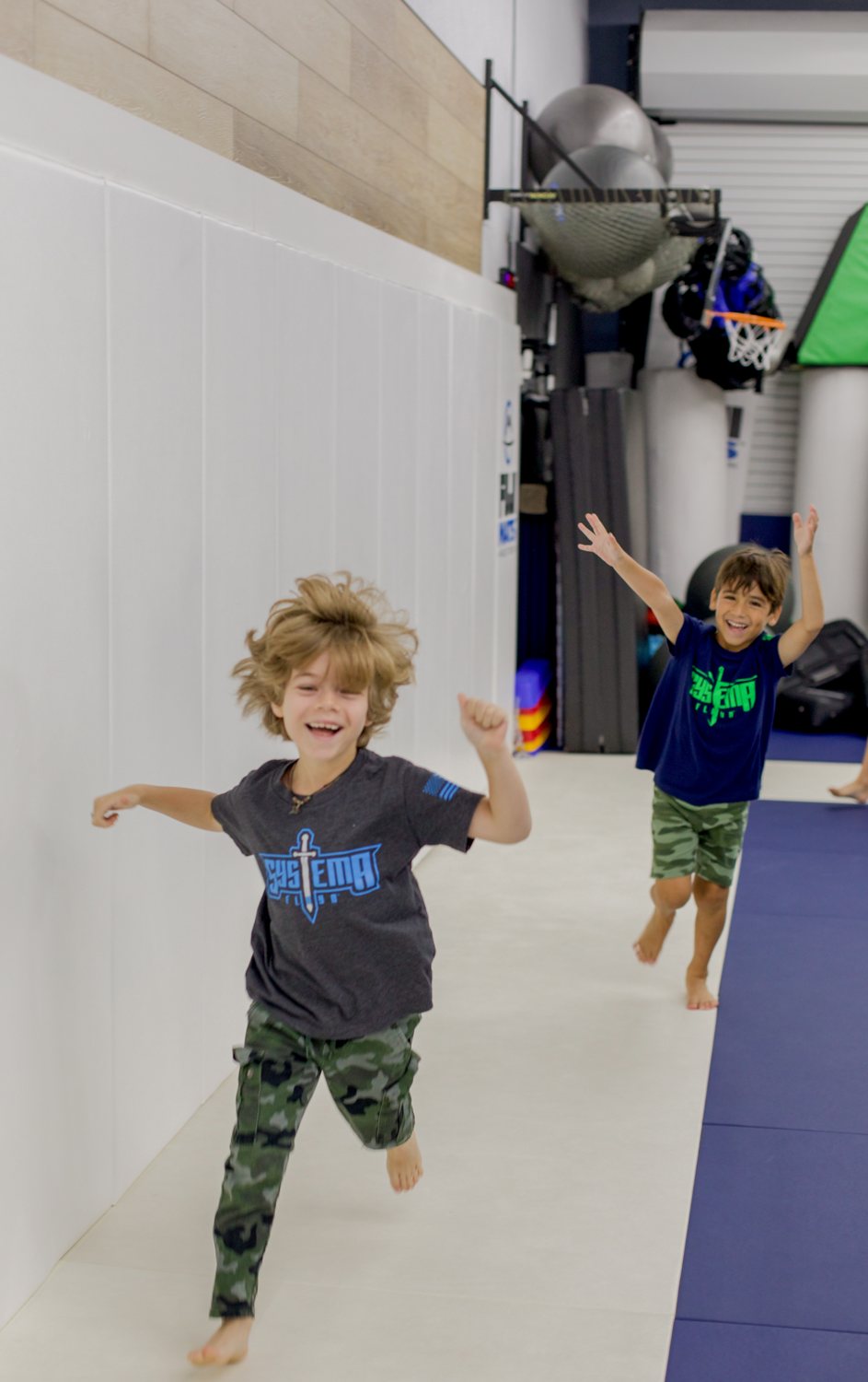 Two boys running across the dojo