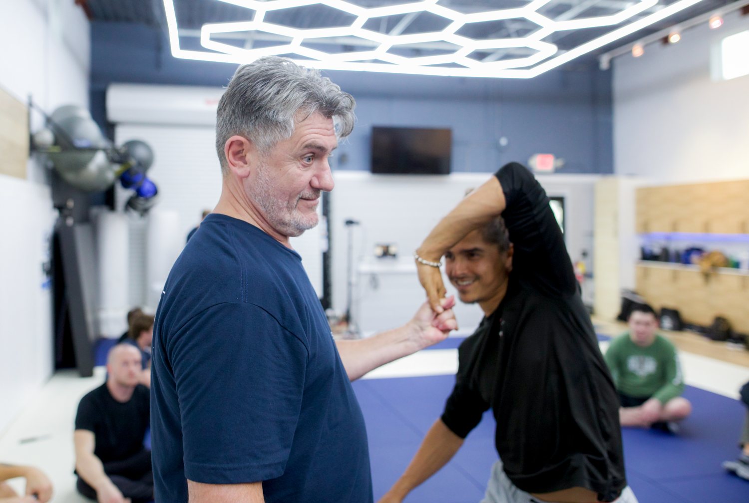 Vladimir Vasiliev guiding a student through an arm movement on the mat