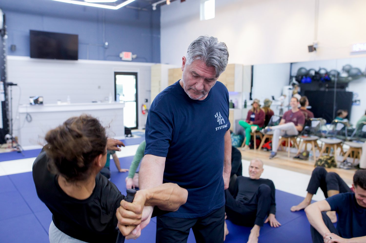 Vladimir Vasiliev working hands-on with a student while the room looks on