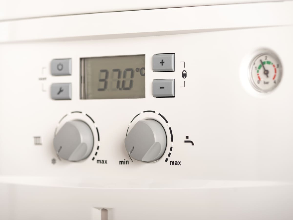  Close-up view of a digital thermostat on a newly installed boiler system showing a temperature of 37 degrees Celsius.