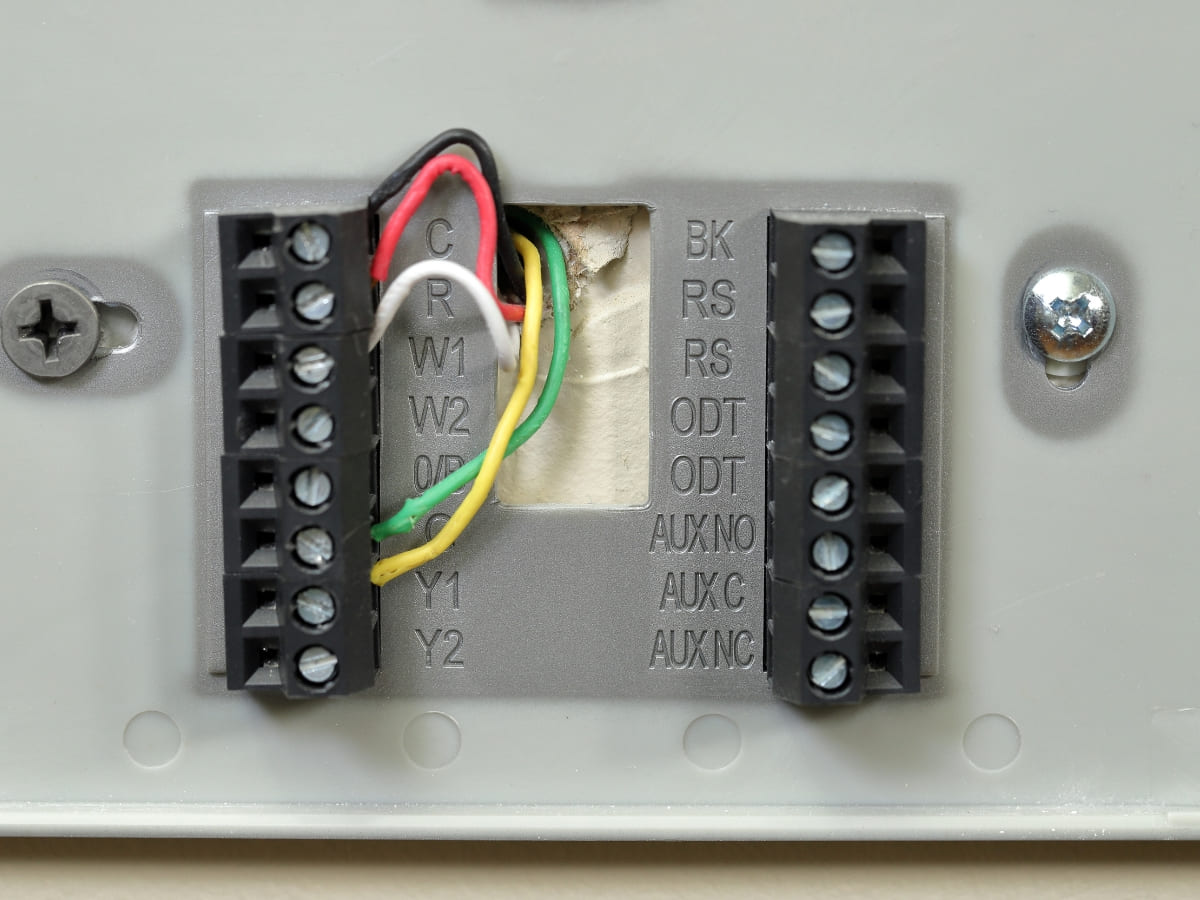 Close-up of a thermostat wiring setup, essential for controlling heating systems in Medford homes.