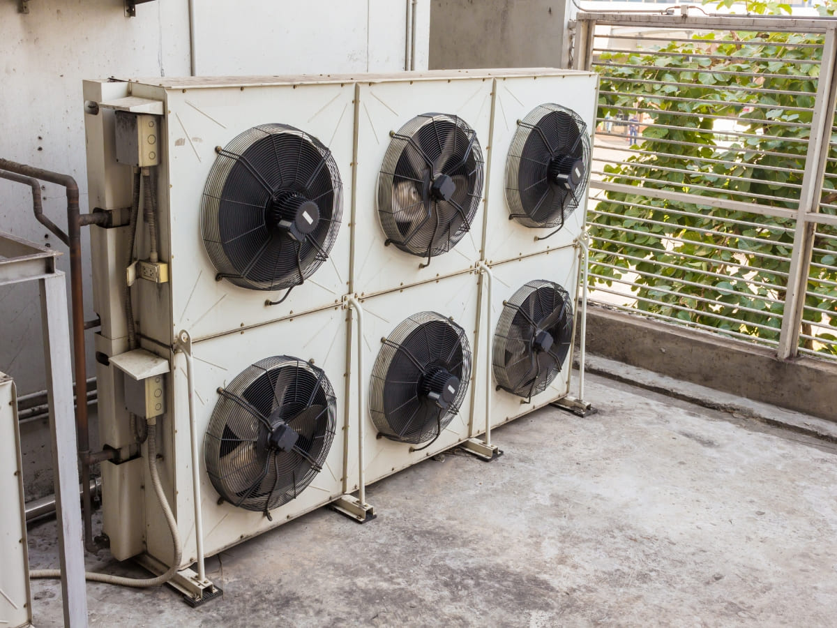 Commercial AC units with six fans mounted on a building exterior