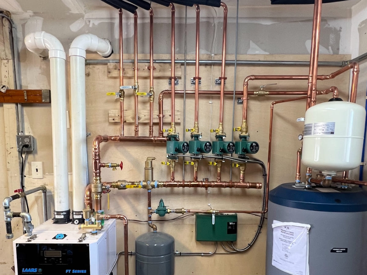 Modern boiler system setup with multiple pipes and a hot water tank