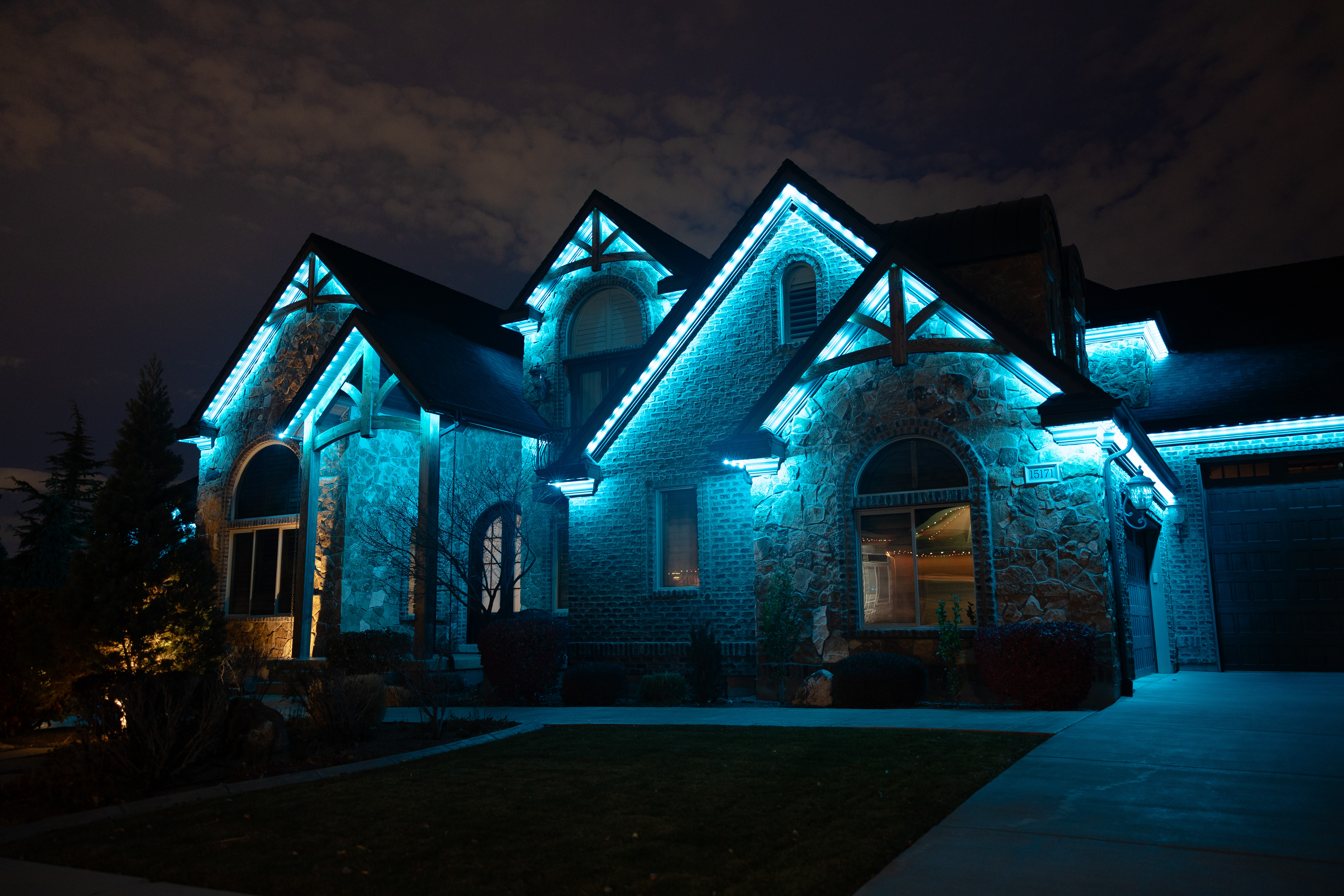 Custom permanent roofline lights illuminating a home at night