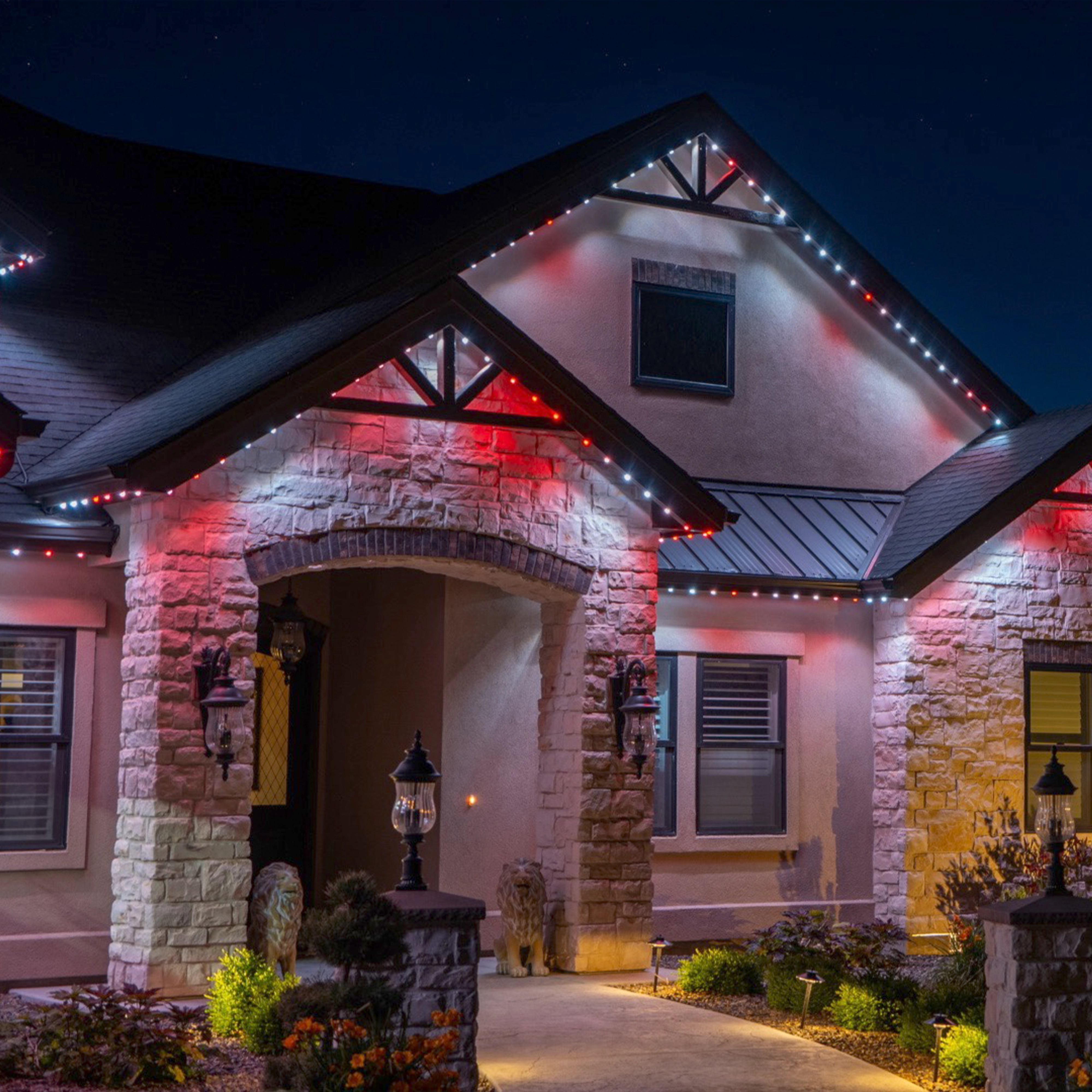 Home roofline illuminated in festive red and white permanent lighting