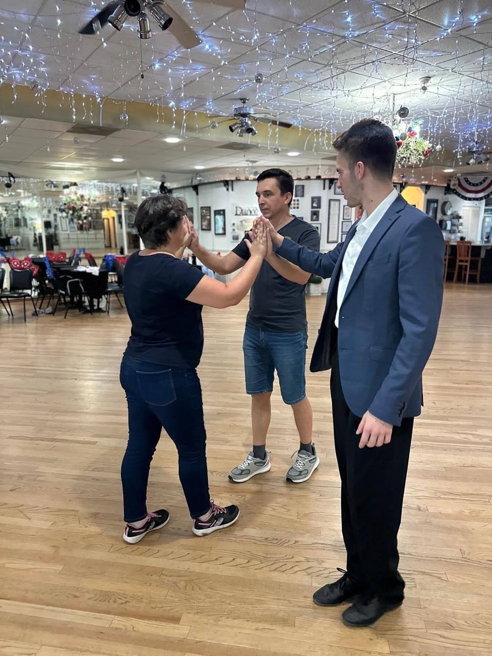Dmytro teaching a beginner her first steps in the ballroom