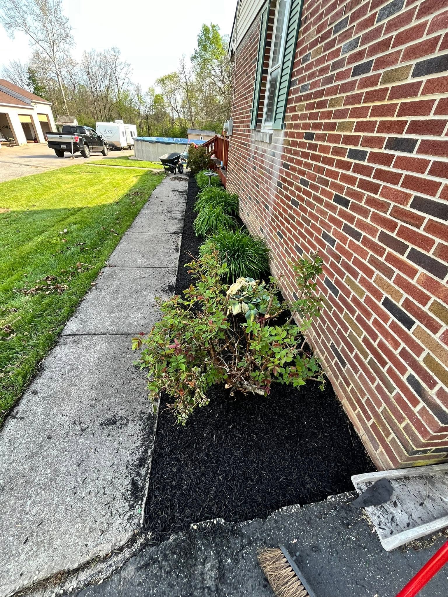 Freshly mulched bed along a brick house and concrete walkway in Carroll County, MD