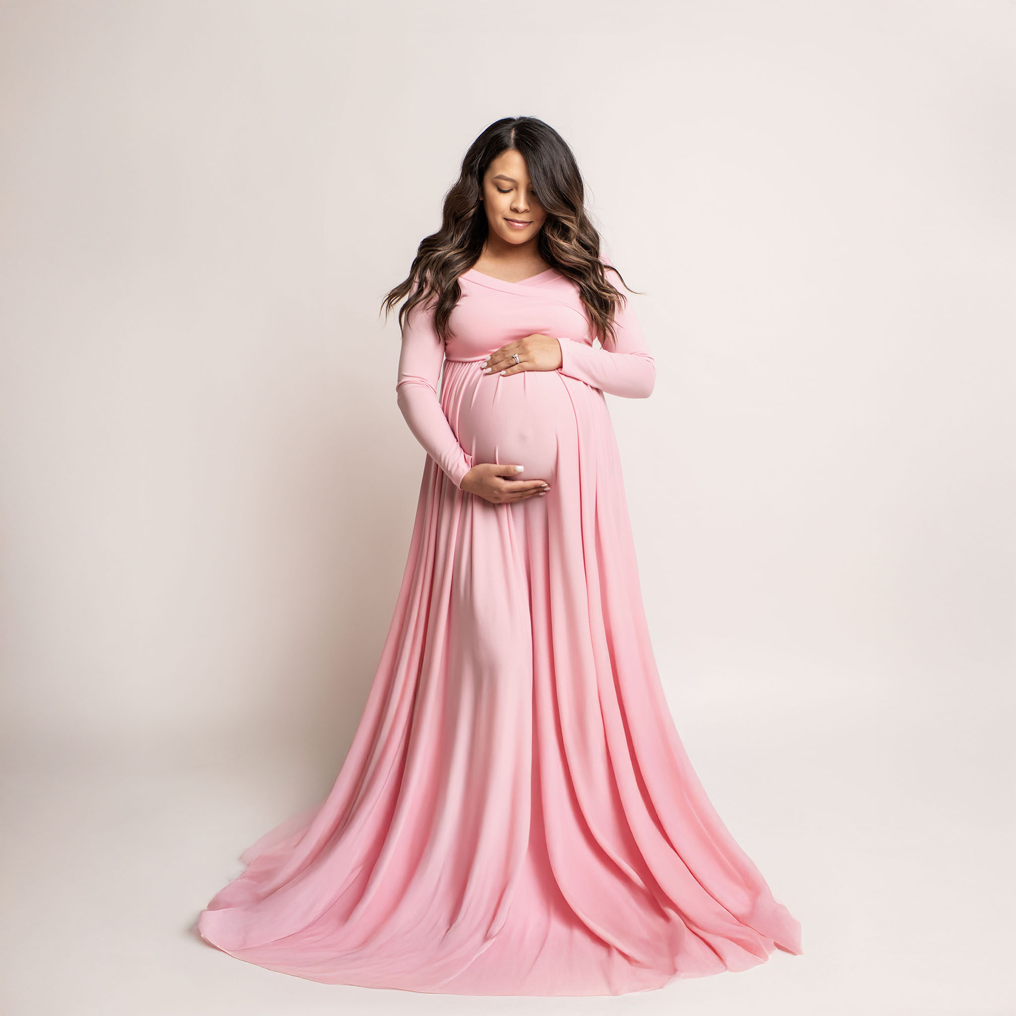 Pregnant female wearing long pink gown