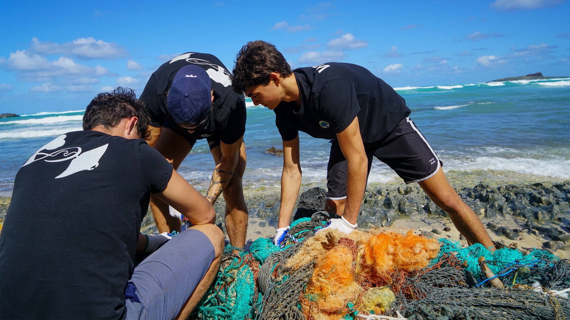 Our cleanup team working on a remote coastline removing a derelict commercial fishing net