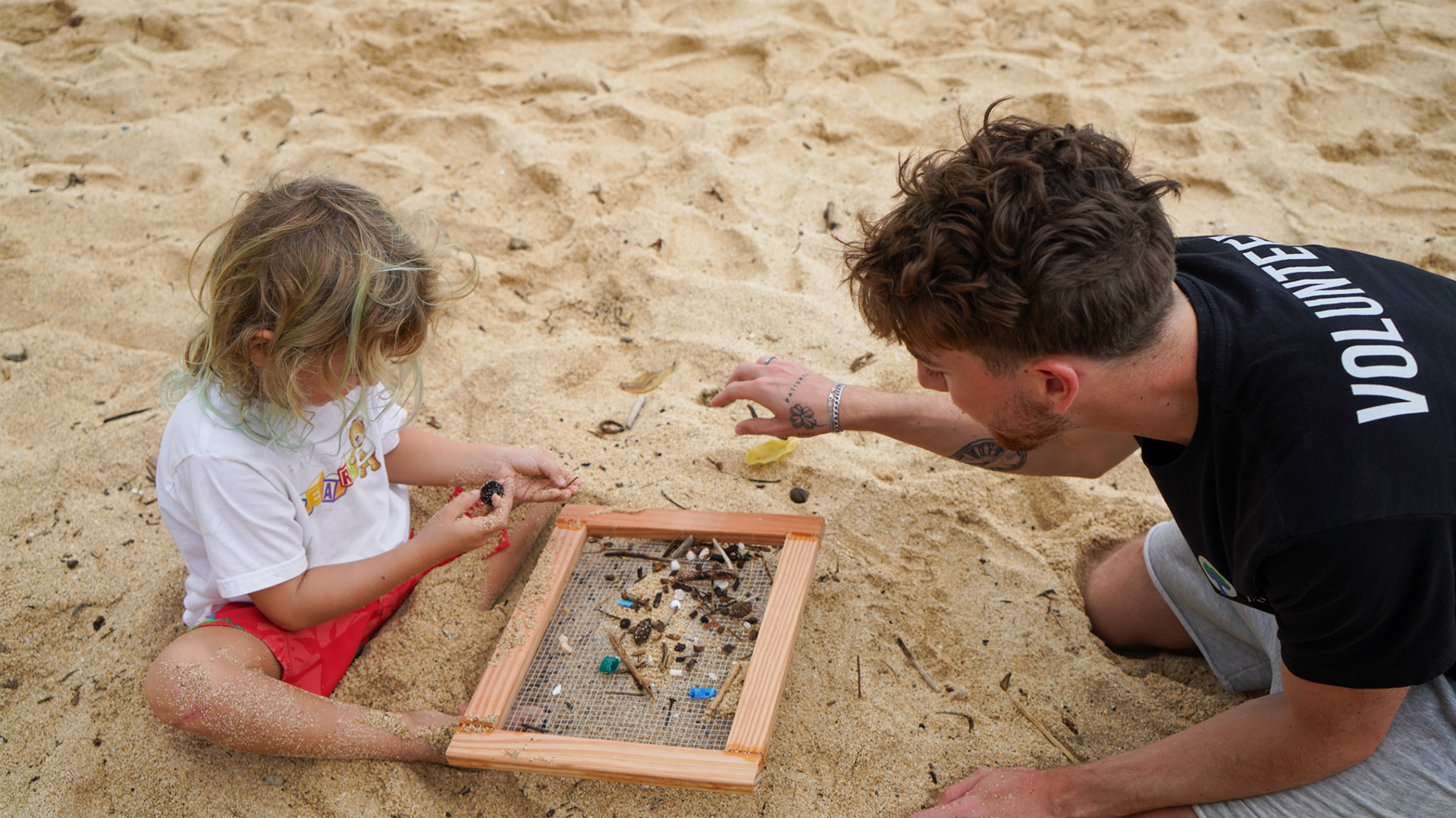 Our education team sand sifting plastic with a student on Oahu, Hawaii