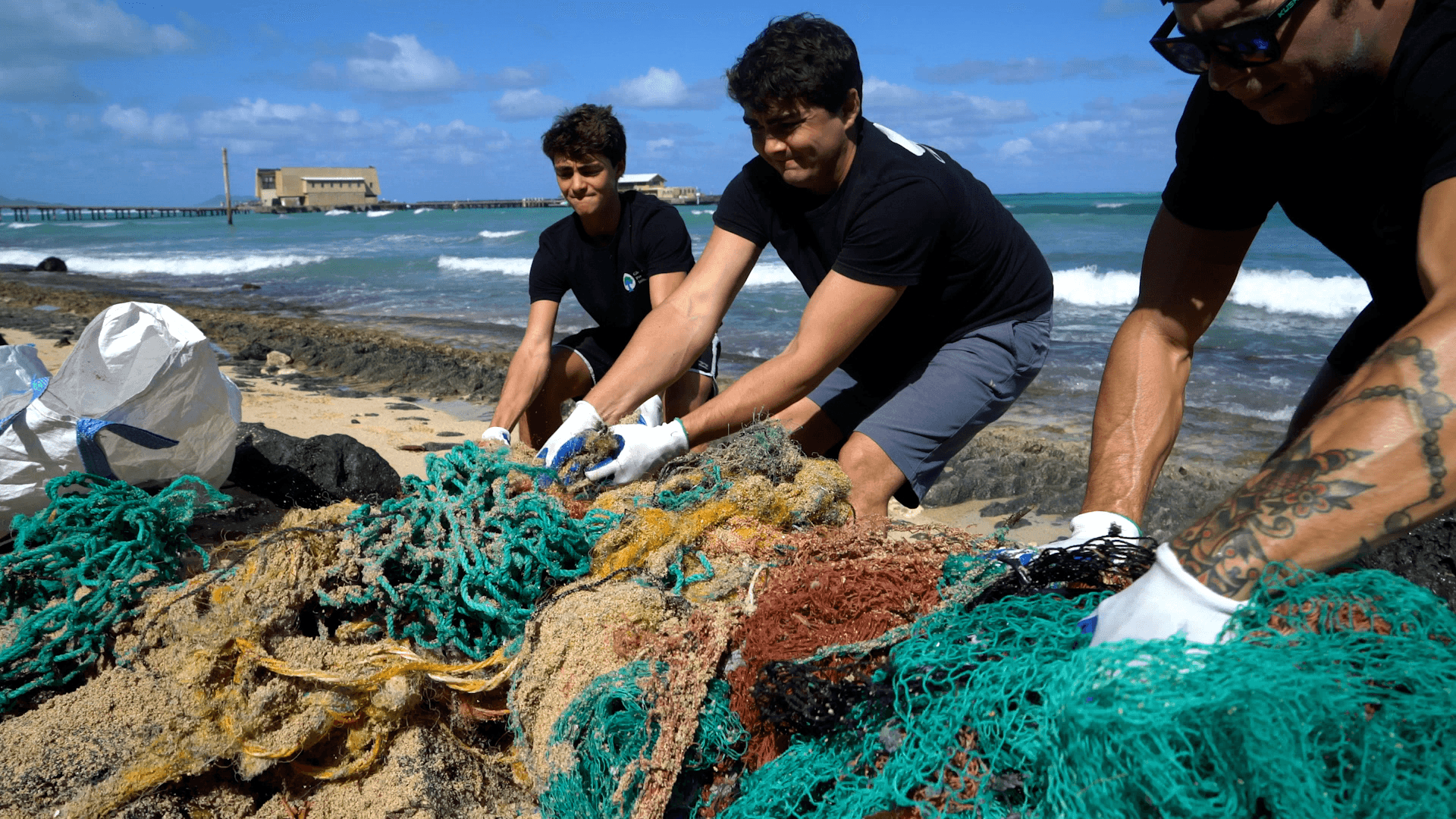 Our cleanup team removing a derelict fishing net from a coastline on Oahu Hawaii