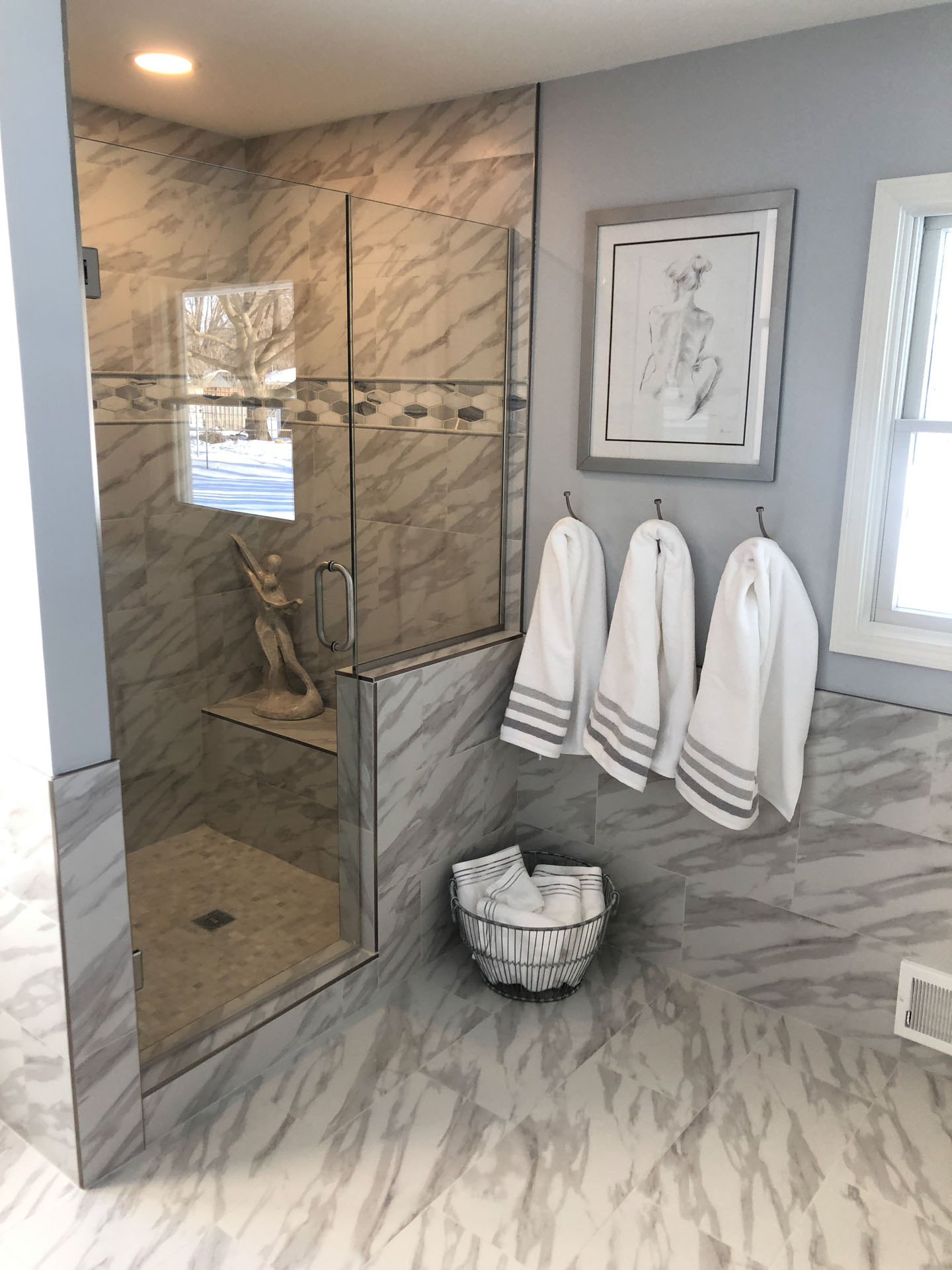 Custom walk-in shower with a penny mosaic floor, framed niche, and large-format wall tile