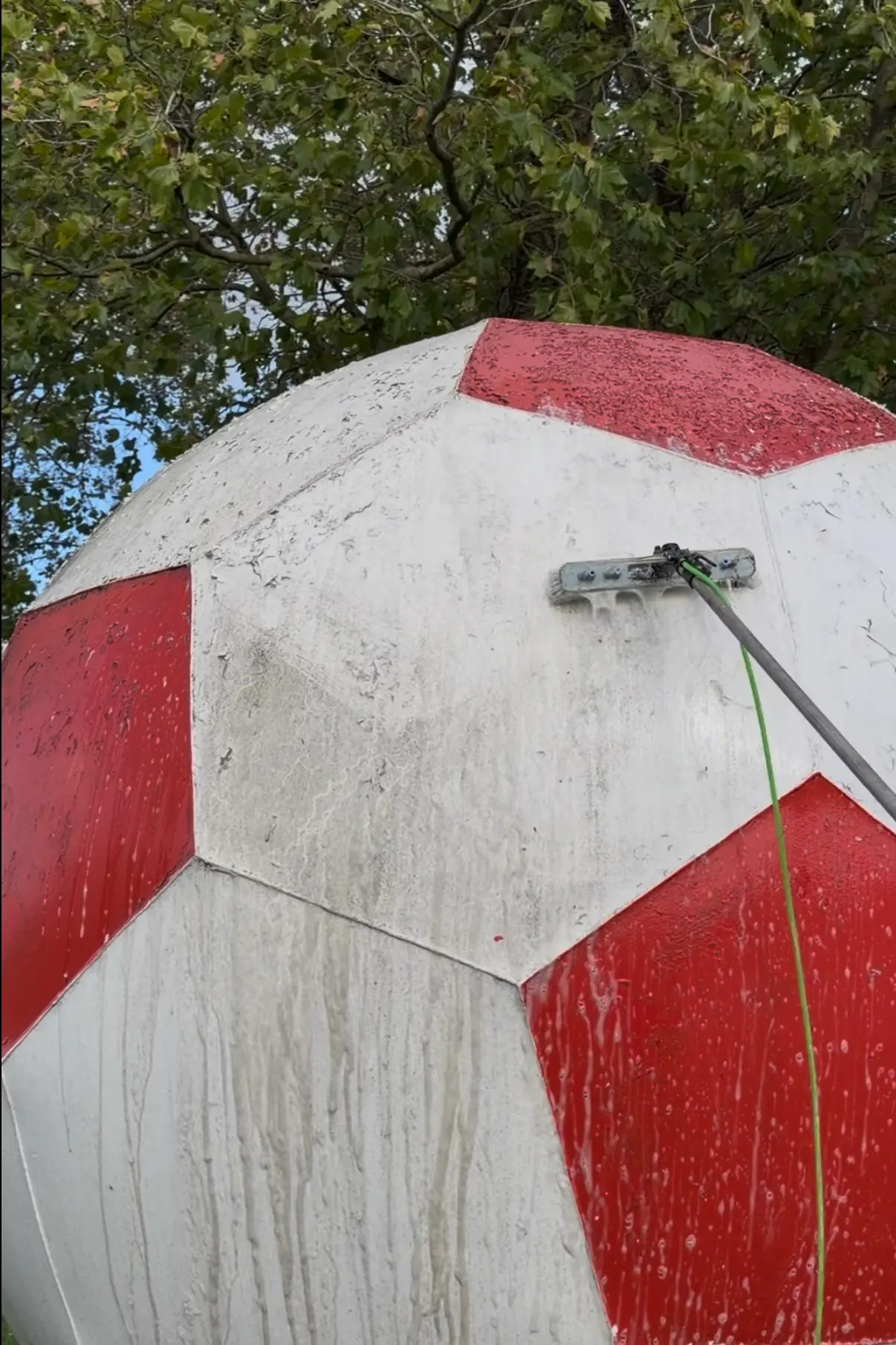 Close-up of the giant Crawley football landmark surface before and during cleaning