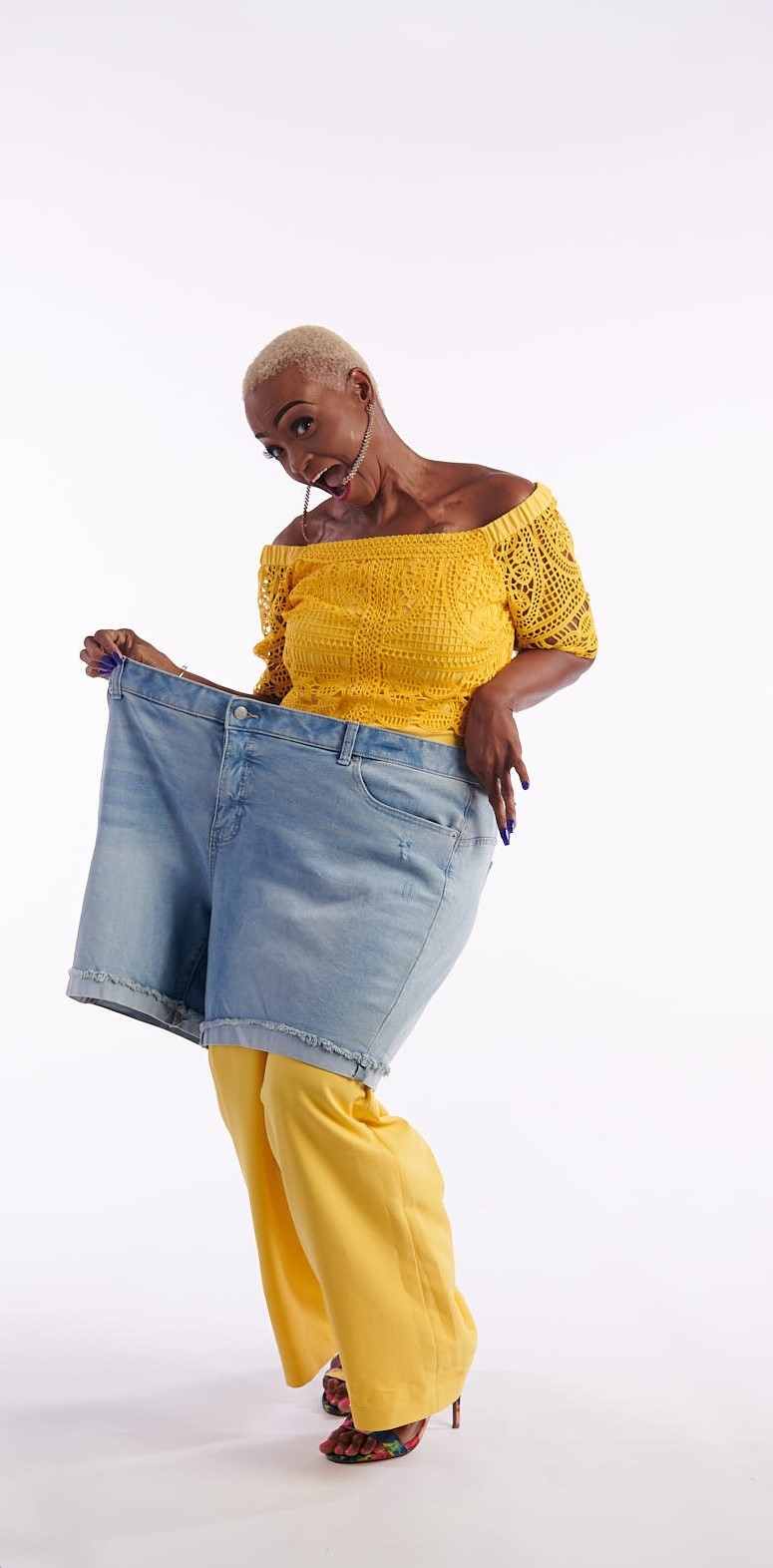 Kenya holding up the jeans she once wore, after releasing more than 468 pounds