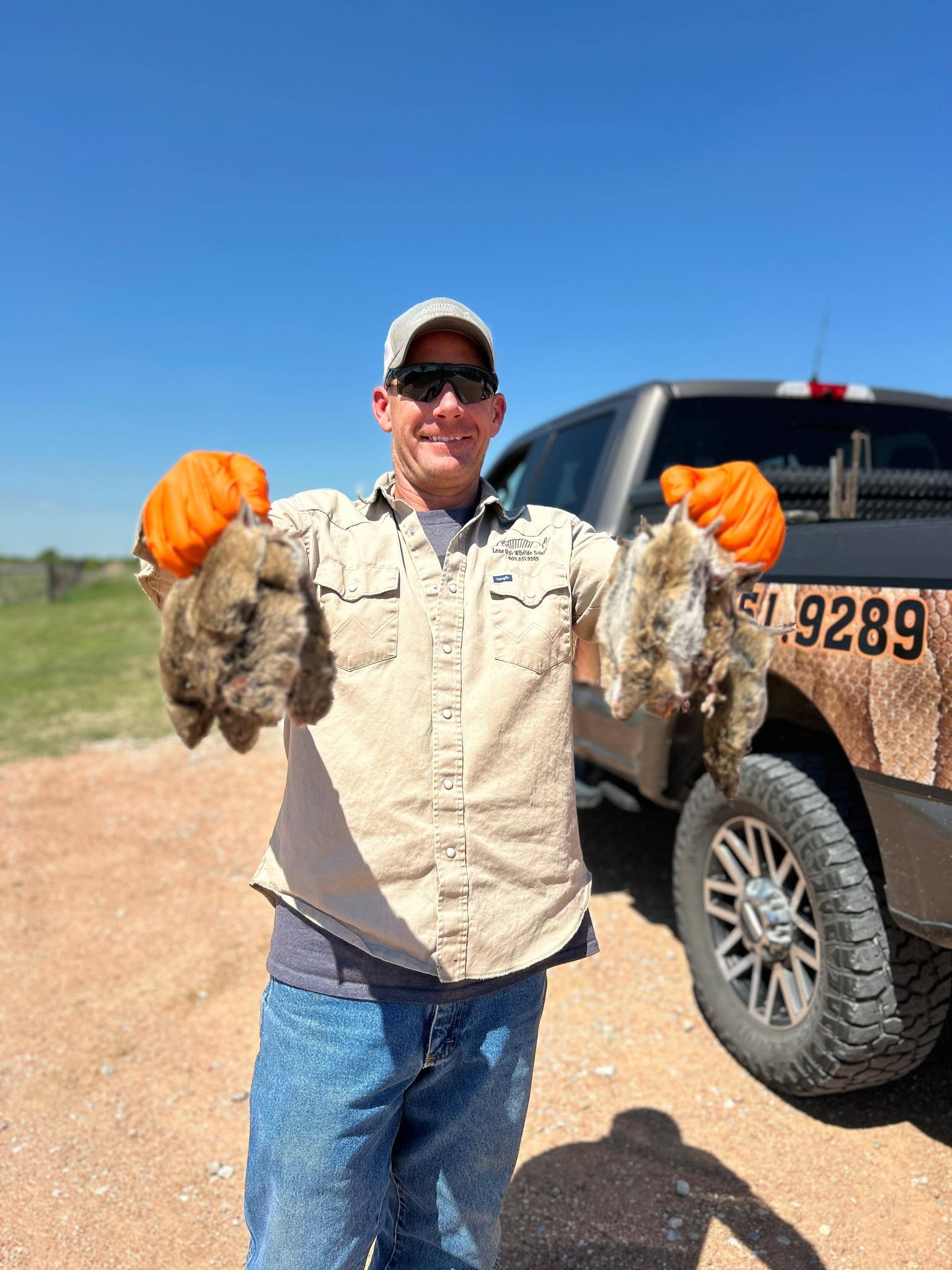 Lone Star Wildlife Solutions technician with captured rat after successful removal from residential property