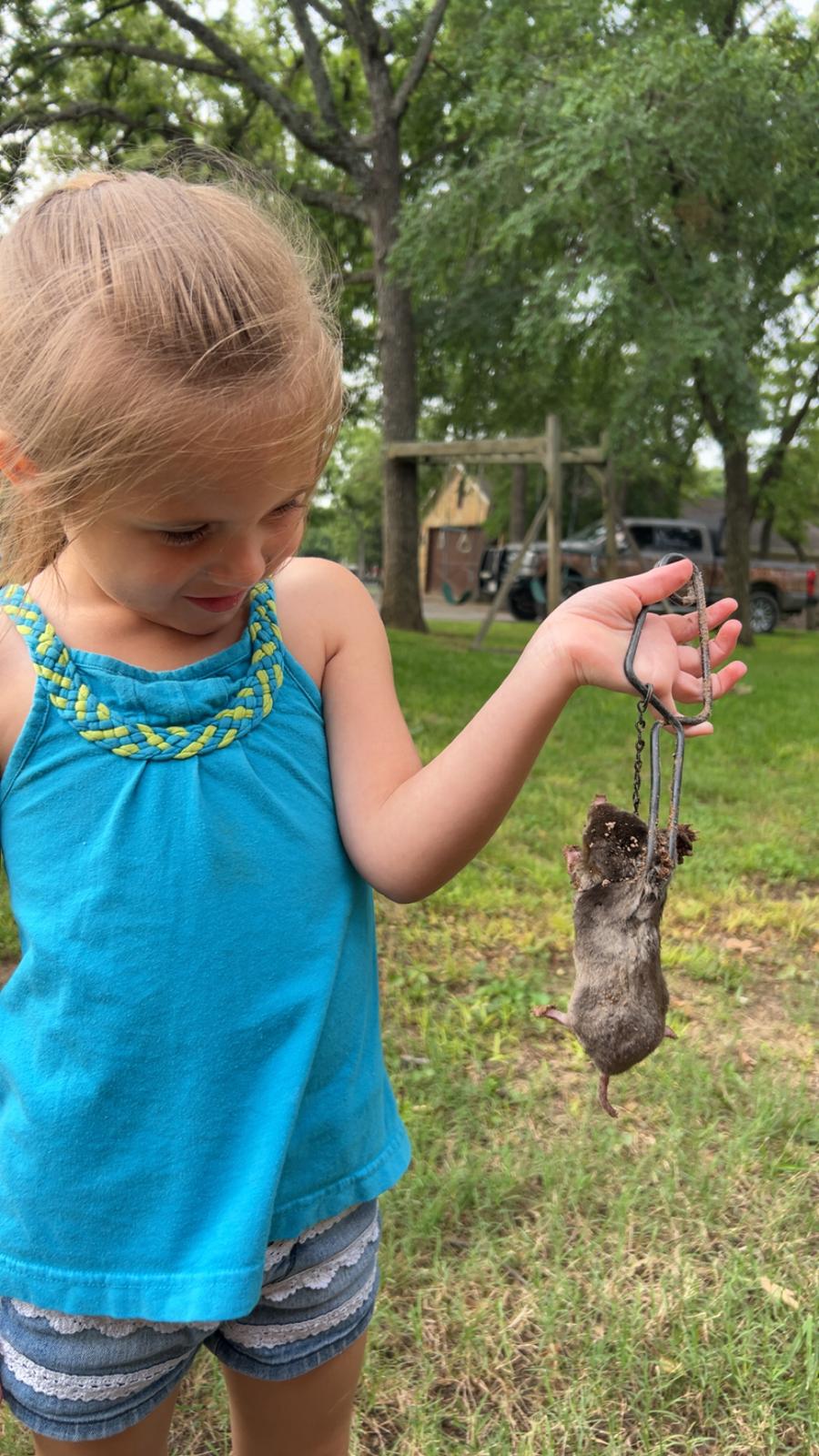 Lone Star Wildlife Solutions technician with captured rat after successful removal from residential property