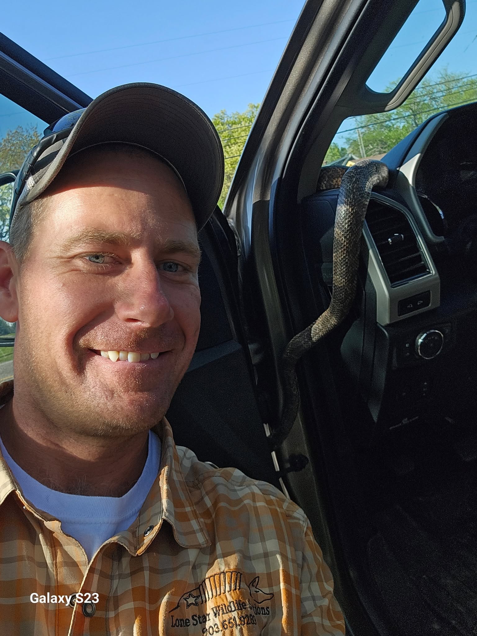 Lone Star Wildlife Solutions technician with captured snake after successful removal from residential property