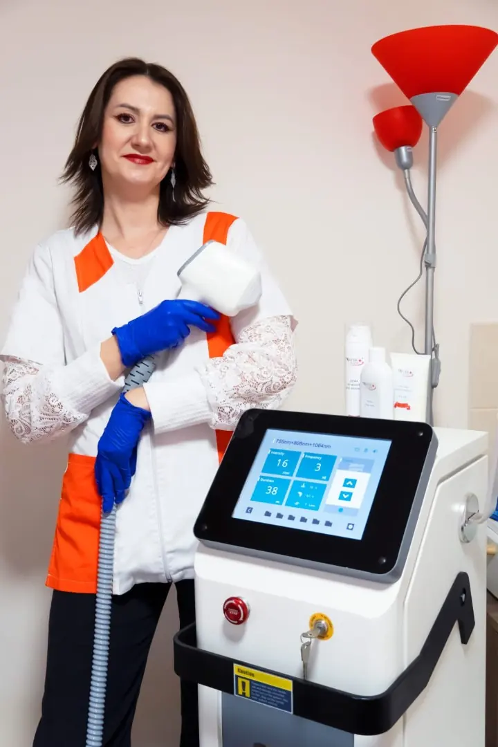 Ramona Vermeșan ținând piesa de mână, lângă aparatul de epilare laser din salon
