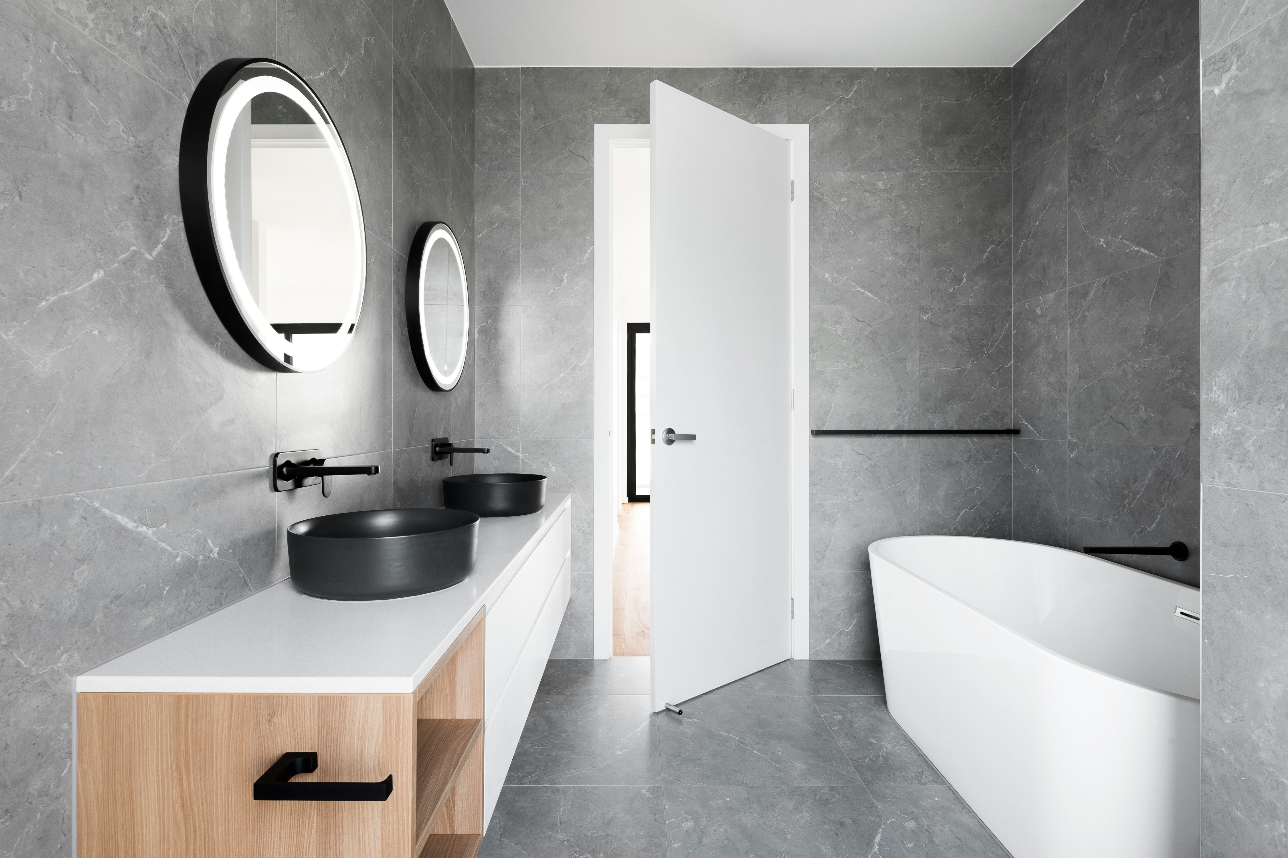 Brand new monochrome bathroom with a freestanding tub and couples sink