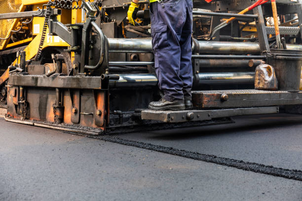 Crew laying fresh asphalt with a paving machine