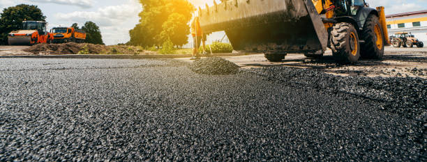 Road construction equipment lined up on wet asphalt