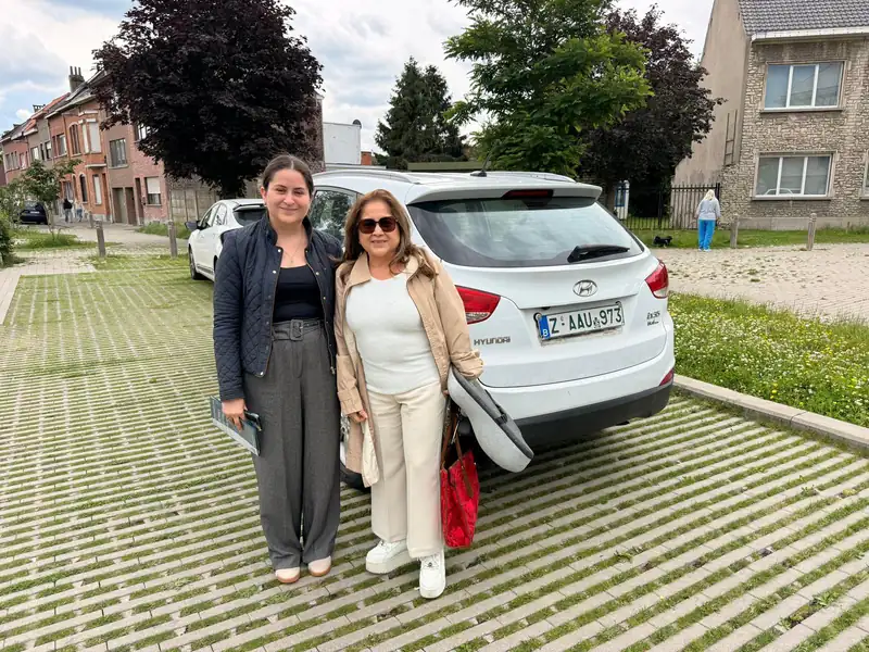 Twee klantes van Automotive Belgium bij hun verkochte witte Hyundai ix35