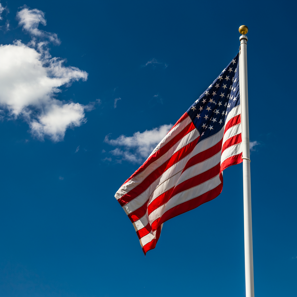 An American flag flying against a blue sky
