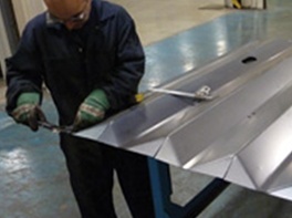 Worker preparing a stainless steel cabinet panel